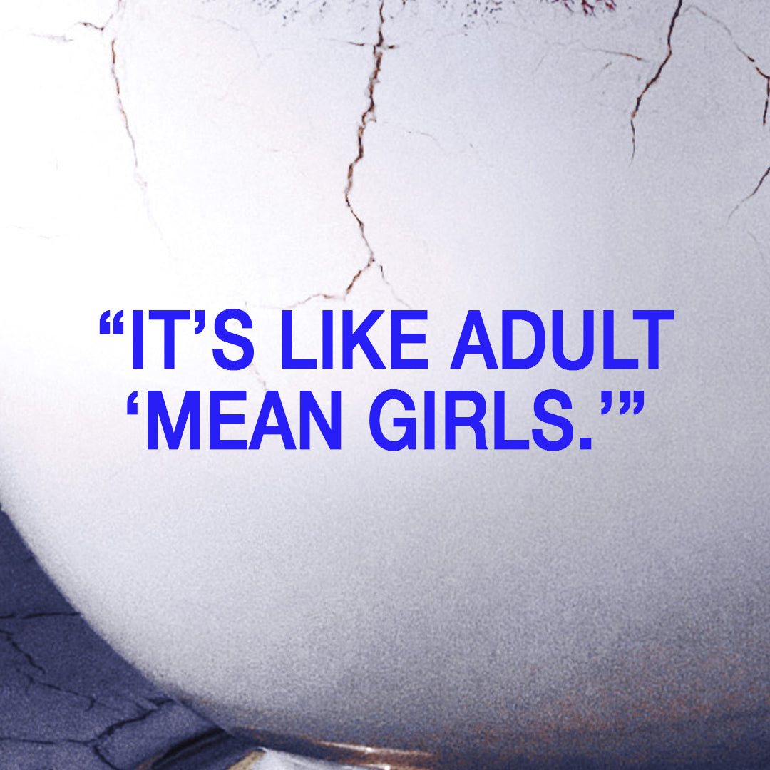 A close-up of a white textured surface with visible cracks and bold blue text reading, “IT’S LIKE ADULT MEAN GIRLS.”